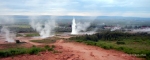 Strokkur erupting, with a view of smaller geysirs surrounding it